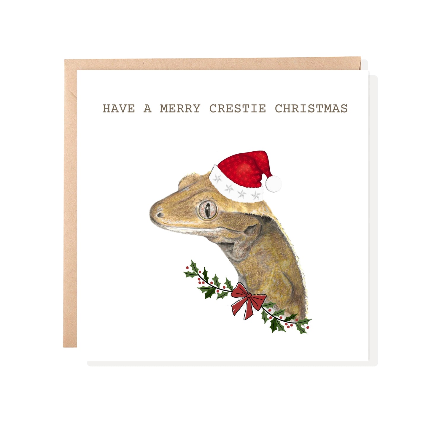 Crested gecko christmas card. A gecko wearing a christmas hat with holly and text