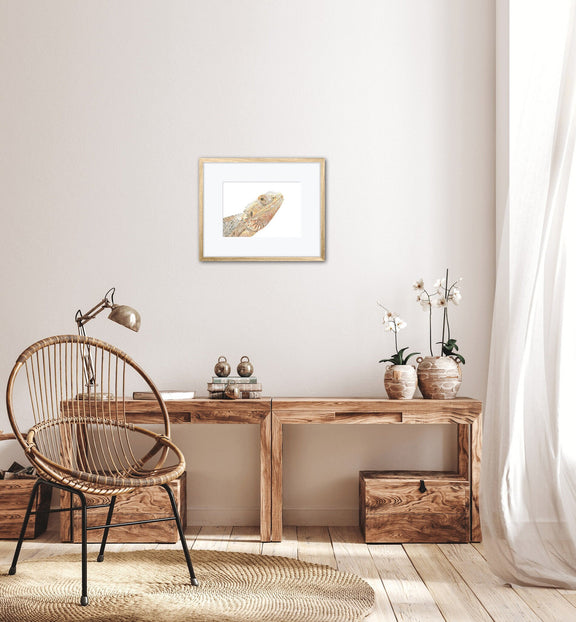 Mounted bearded dragon print on the wall in a home office with wooden desk, chair, and decor elements.